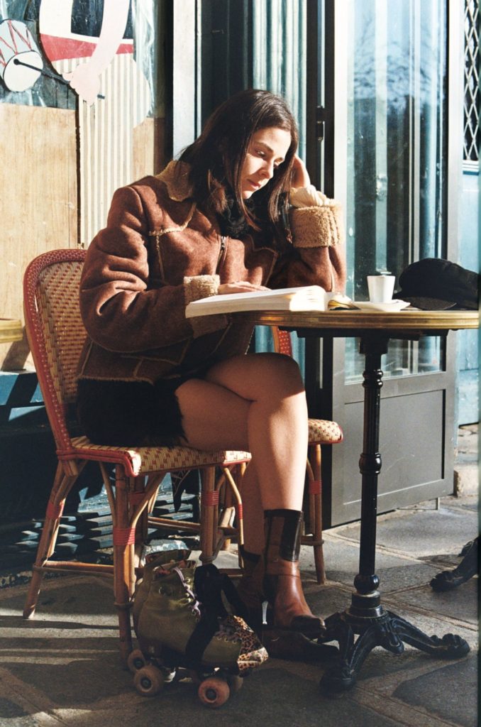 portrait of a young woman in Paris reading at a terrace, taken with analog canon f1